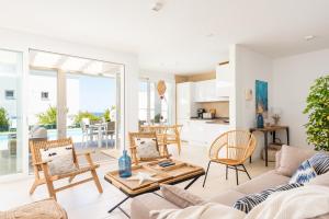 een woonkamer met een bank, stoelen en een tafel bij Villa Galerna in Son Bou