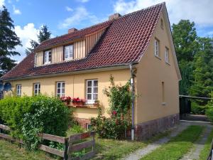 ein gelbes Haus mit rotem Dach in der Unterkunft Ferienwohungen Domäne Süpplingenburg in Süpplingenburg