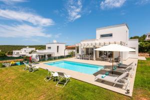 een villa met zwembad en huis bij Villa Galerna in Son Bou