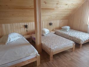 a room with two beds in a wooden cabin at RUNČI in Lautere +37 photos