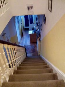 a staircase leading up to a kitchen and a hallway at Seamore Guest House in Great Yarmouth