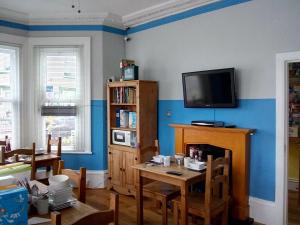 a living room with a table and a tv on the wall at Seamore Guest House in Great Yarmouth