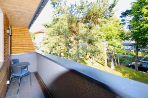 - un balcon avec une table, des chaises et des arbres dans l'établissement Ameba, à Mielno