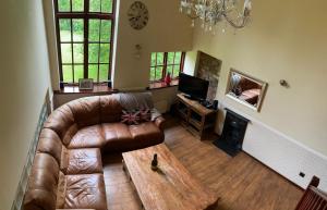 a living room with a leather couch and a coffee table at Jackfield Mill Ironbridge Gorge in Telford