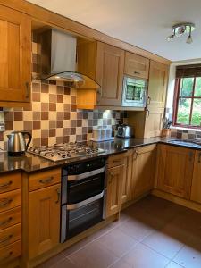 uma cozinha com armários de madeira e um forno com placa de fogão em Jackfield Mill Ironbridge Gorge em Telford