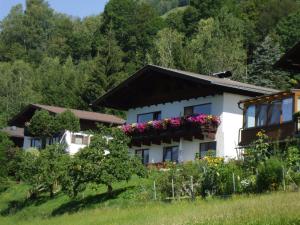 ein Haus mit Blumen an den Fenstern in der Unterkunft Schernthaner in Taxenbach