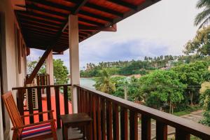 a balcony with two chairs and a view of the water at Seafood Restaurant and Motel in Tangalle