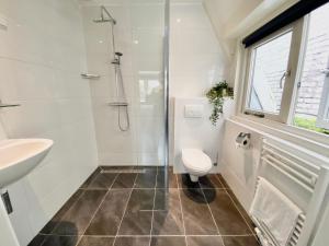 a bathroom with a shower and a toilet and a sink at Church Square Studio in Zandvoort +12 photos