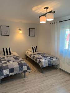 a bedroom with two beds and a window and a ceiling at Apartamenty Wydminy in Wydminy