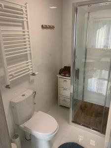 a white bathroom with a toilet and a shower at Apartamenty Wydminy in Wydminy +24 photos