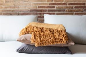 una pila de almohadas sentadas en una cama en DestinationBCN Universitat Apartments, en Barcelona