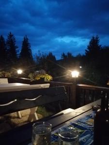 una mesa en una terraza por la noche con luces en Casa Verde en Voronet