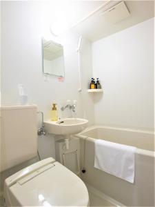 a white bathroom with a toilet and a sink at SHIN YOKOHAMA SK HOTEL - Smoking - Vacation STAY 86108 in Yokohama