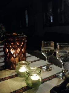 uma mesa com copos de vinho e velas em Casa Verde em Voronet