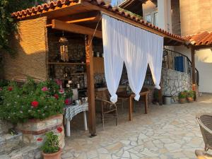 a pergola with a table and chairs on a patio at Stefanel View-Frederika in Himare