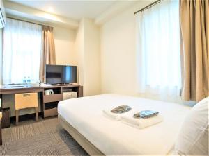 横浜市にあるSHIN YOKOHAMA SK HOTEL - Non Smoking - Vacation STAY 86107のベッド、デスク、テレビが備わるホテルルームです。