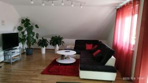 ein Wohnzimmer mit einem Sofa und einem Tisch in der Unterkunft Ferienwohnung Valerie in Ettenheim
