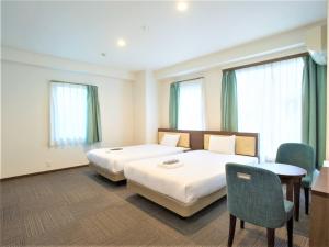 a hotel room with two beds and a table and chairs at SHIN YOKOHAMA SK HOTEL - Non Smoking - Vacation STAY 86110 in Yokohama