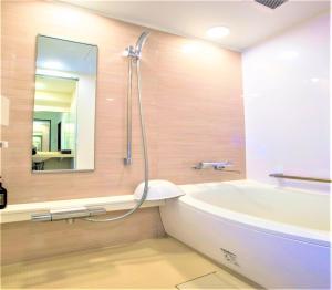 a bathroom with a tub and a sink and a mirror at SHIN YOKOHAMA SK HOTEL - Non Smoking - Vacation STAY 86110 in Yokohama
