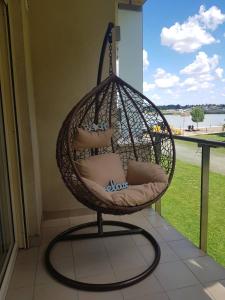 una silla colgante con almohadas en el porche en Relax and Spa - DeLux Apartman, en Velence