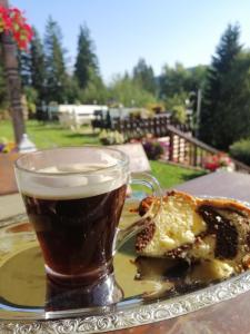 un verre de bière à côté d'un morceau de pain et d'une boisson dans l'établissement Casa Verde, à Voroneț