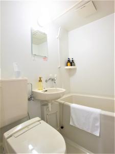 een witte badkamer met een toilet en een wastafel bij SHIN YOKOHAMA SK HOTEL - Non Smoking - Vacation STAY 86104 in Yokohama