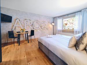 a bedroom with a large bed and a table with chairs at Derby 14 in Arosa