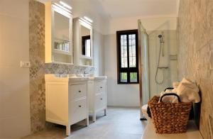 Un baño blanco con lavabo y ducha. en Villa Fataga - Unique villa with heated pool, en Fátaga