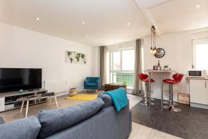 a living room with a blue couch and a tv at VIEUX SCHILIK / Parking / Tram / Parlement / Proche Strasbourg Centre in Schiltigheim