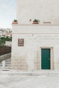 una puerta verde al lado de un edificio en I Tre Portali Luxury Suites en Matera