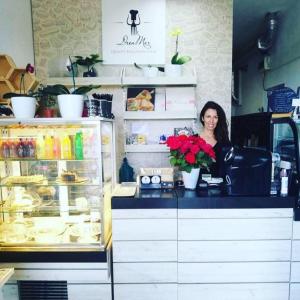 a woman sitting at a counter in a bakery at Dream House in Tsarevo