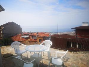 a table and chairs on a balcony with a view at Алми Almi in Sveti Vlas