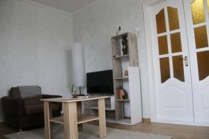 een woonkamer met een bureau met een computer en een stoel bij Апартаменти на Космонавтів in Vinnytsya