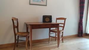a wooden table with a radio on it with two chairs at L`Atelier in Saint-Martial-Viveyrol