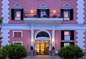 a pink building with a door and a balcony at Hotel Mare Blu Terme in Ischia
