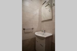 bagno con lavandino e specchio di Sea view apartment Lovran a Lovran (Laurana)
