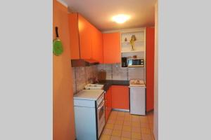 a small kitchen with orange cabinets and a dishwasher at Sea view apartment Lovran in Lovran +12 photos