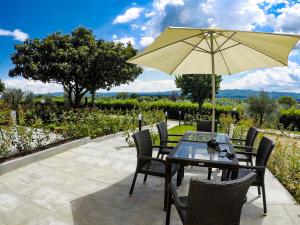 een patio met een tafel en stoelen met een parasol bij 7 Bridges Apartment in Loro Ciuffenna
