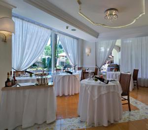 een restaurant met twee tafels met witte tafelkleden bij Hotel Mare Blu Terme in Ischia