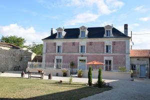 een groot roze huis met een hek ervoor bij La Galuche in Angliers