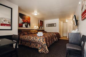 a hotel room with a bed and two chairs at Vintage Lakeside Inn in Big Bear Lake