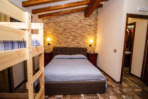 a bedroom with two bunk beds and a brick wall at Le Muse Country House - Gole Alcantara in Motta Camastra