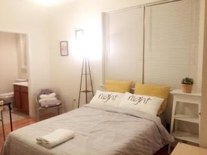 um quarto com uma cama grande e uma luz nocturna em Cozy bedrooms at University City in Philadelphia em Filadélfia