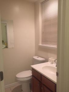 ein Bad mit einem WC, einem Waschbecken und einem Fenster in der Unterkunft Cozy bedrooms at University City in Philadelphia in Philadelphia