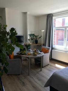 een woonkamer met een tafel en 2 stoelen bij ambrosius in Brugge