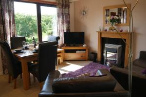 a living room with a table and a fireplace at Caisteal Liath in Lochinver