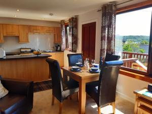 a kitchen and dining room with a table and chairs at Caisteal Liath Chalets in Lochinver +42 photos