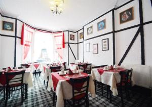 ブラックプールにあるThe Chelston Bed and Breakfastの赤いテーブルクロスのテーブルと椅子が備わるレストラン