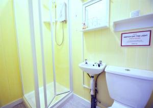 a bathroom with a shower and a toilet and a sink at The Chelston Bed and Breakfast in Blackpool