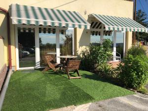 a patio with a table and two chairs on grass at Balatonalmádi Apartmanház in Balatonalmádi